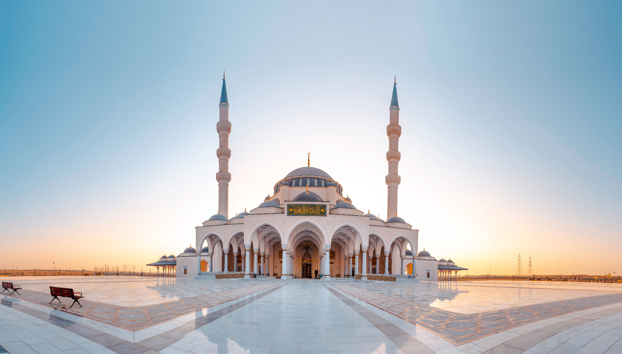 Majestic exterior of Sharjah Grand Mosque showcasing intricate Islamic architecture.